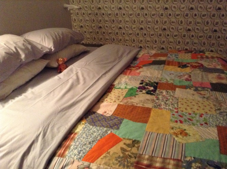 Spread out in the middle of the bed under a Fogo Island Quilt.